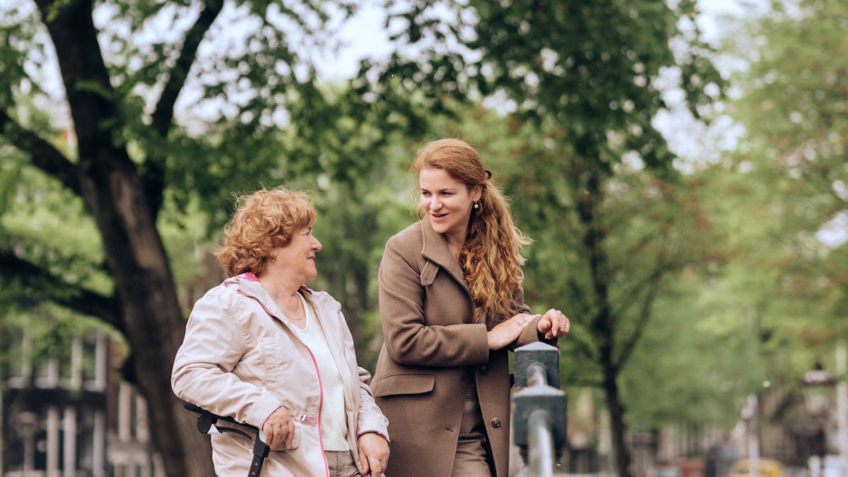 Senior woman seated on her rollator outdoors near a scenic canal on a summer day